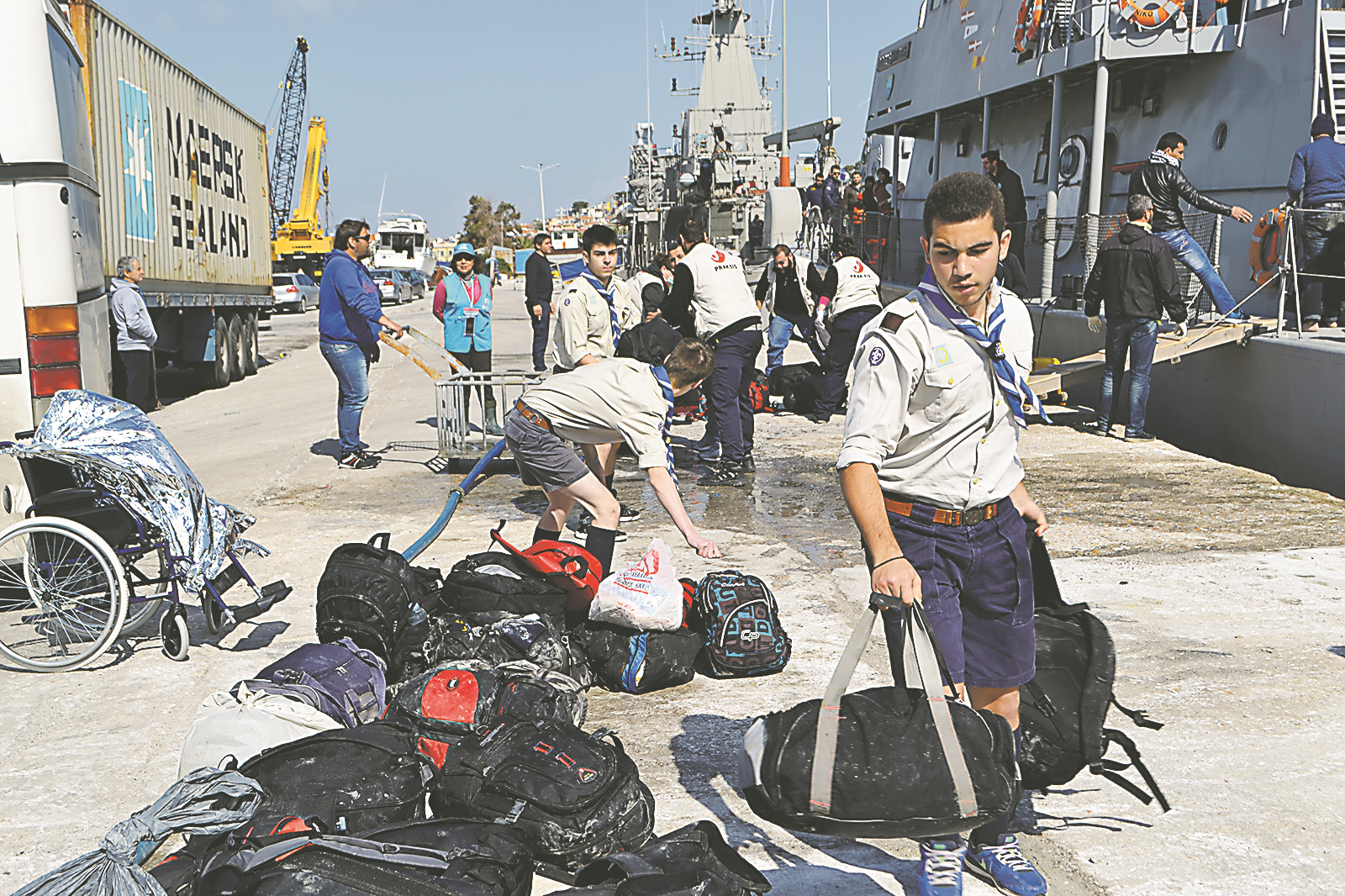 Μέλη του 3ου Σώματος προσκόπων του νησιού, μεταξύ των οποίων οι Γιάννης Σβώρος και Ξενοφών Κουκούτας βοηθούν στη μεταφορά σακιδίων των προσφύγων που μόλις έχουν φθάσει στο λιμάνι της Μυτιλήνης Μέλη του 3ου Σώματος προσκόπων του νησιού, μεταξύ των οποίων οι Γιάννης Σβώρος και Ξενοφών Κουκούτας βοηθούν στη μεταφορά σακιδίων των προσφύγων που μόλις έχουν φθάσει στο λιμάνι της Μυτιλήνης